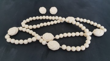 Avon 'Carved Accent' 1988 Ivoorkleurige set met oorbellen en ketting op zwart