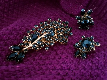 Beaujewels goudkleurige set van broche en oorbellen met veel zwarte steentjes en filigrain achterkant op muts