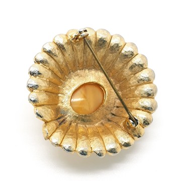 Round brushed goldtone brooch with butterscotch centerstone surrounded by clear rhinestones - Bliinkt