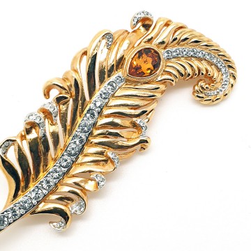 Crystaline - goldtone feather brooch with clear crystals and amber coloured teardrop shaped rhinestone - Bliinkt