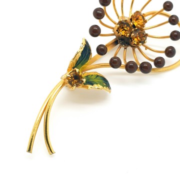 Delicate goldtone flower brooch with enamel leaves and amber coloured rhinestones - Bliinkt