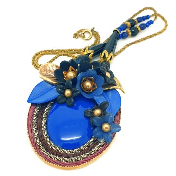 Early 20th century necklace with oval pendant plastic cabochon and flowers in the colours blue gold and black surrounded by dark red and goldtone cord - Bliinkt