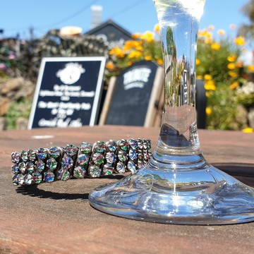 G & Co stretcharmband met regenboogkleurige strass in de zon