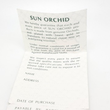 Goldplated orchid necklace pendant and brooch warranty card