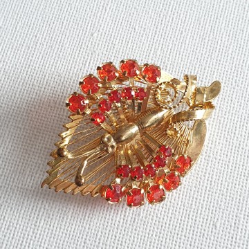 Goldtone butterfly sitting on wired leaf with red rhinestone wings - brooch