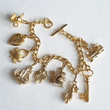 Goudkleurige bedelarmband met tien bedeltjes en T-sluiting