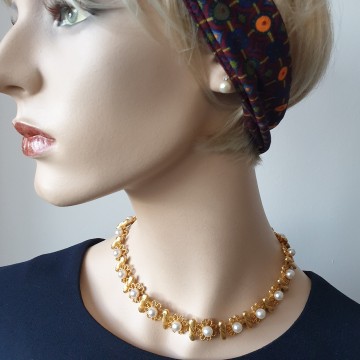 Korte goudkleurige ketting met bloemetjes en faux parels