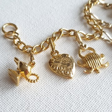 Goudkleurige bedelarmband met tien bedeltjes en T-sluiting