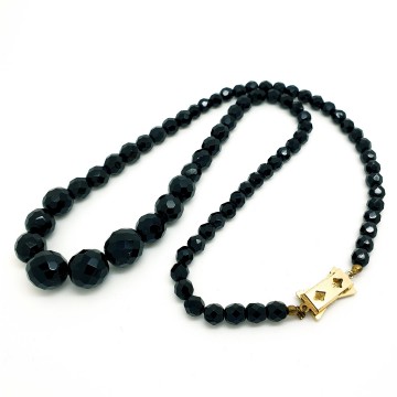 Ketting met zwarte facetgeslepen glaskralen en strikslotje