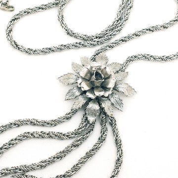 Long silvertone rope necklace with a floral centerpiece and multiple rope chain tassels - Bliinkt