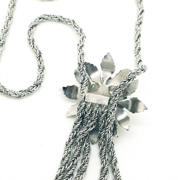 Long silvertone rope necklace with a floral centerpiece and multiple rope chain tassels - Bliinkt