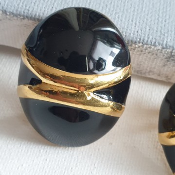 Monet grote eivormige goudkleurige oorbellen met zwart emaille