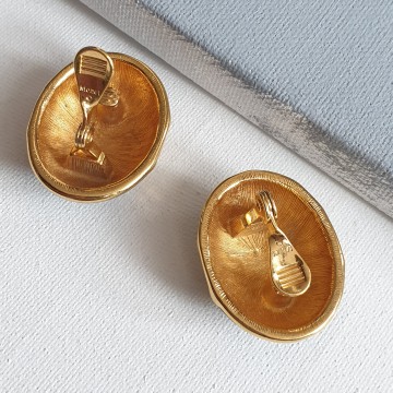 Monet grote eivormige goudkleurige oorbellen met zwart emaille