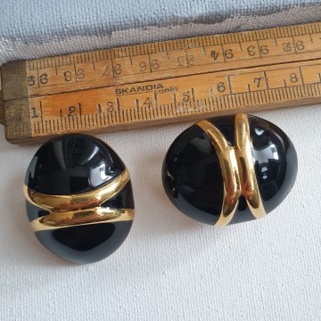 Monet grote eivormige goudkleurige oorbellen met zwart emaille