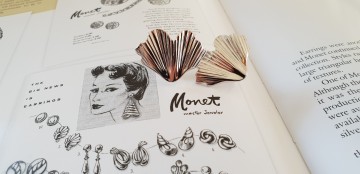 Monet zilverkleurige oorbellen ginkgoblad 60's op boek