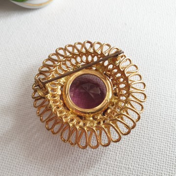 Round goldtone brooch with amethist coloured glass stone back