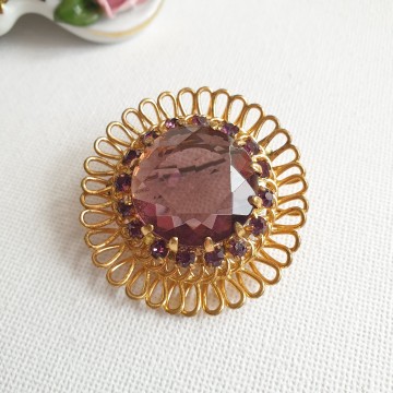 Round goldtone brooch with amethist coloured glass stone