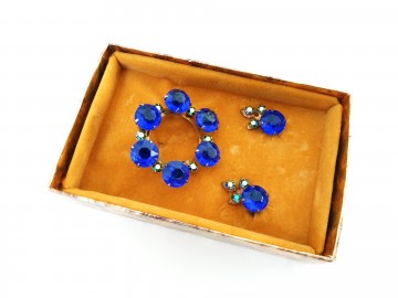 Set van oorbellen en ronde broche met koningsblauwe stenen en heldere strasssteentjes in box