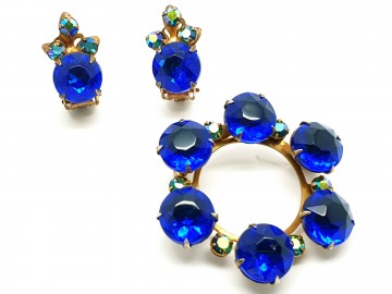 Set van oorbellen en ronde broche met koningsblauwe stenen en heldere strasssteentjes