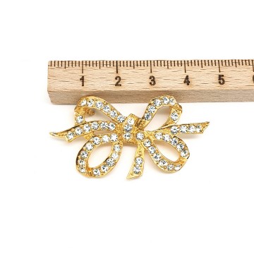 Sphinx - goldtone bow brooch with clear rhinestones - Bliinkt