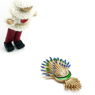 Trifari goudkleurige broche in vorm van korenschoven met blauw en groen emaille uiteinden met popje